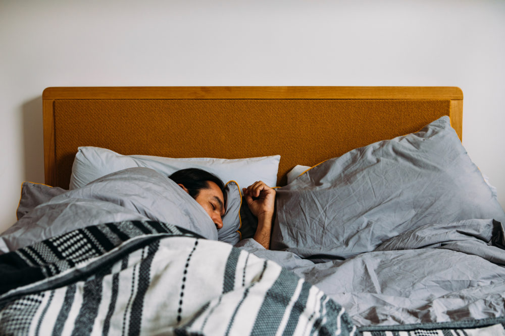 A Man Sleeping In Bed At Day Time