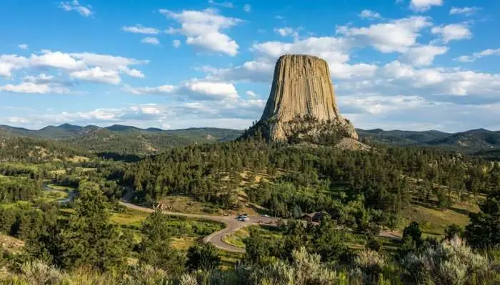 The towering geometric rock formation of Devils Tower rising sharply against the Wyoming sky above the Black Hills.